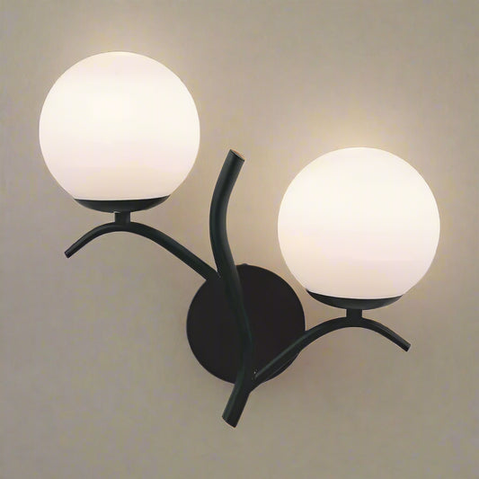 Wall-mounted lamp with two spherical glass shades on a white background