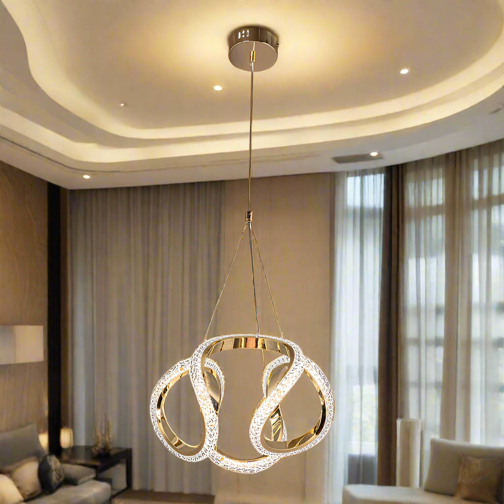 Modern pendant light with gold finish and crystal accents on a white background