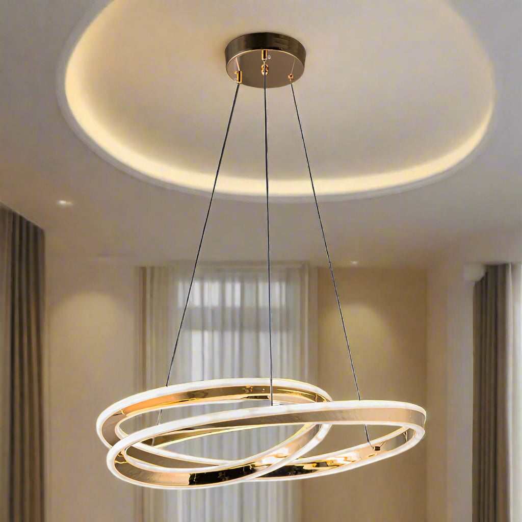 Gold pendant light with two interlocking rings on a white background
