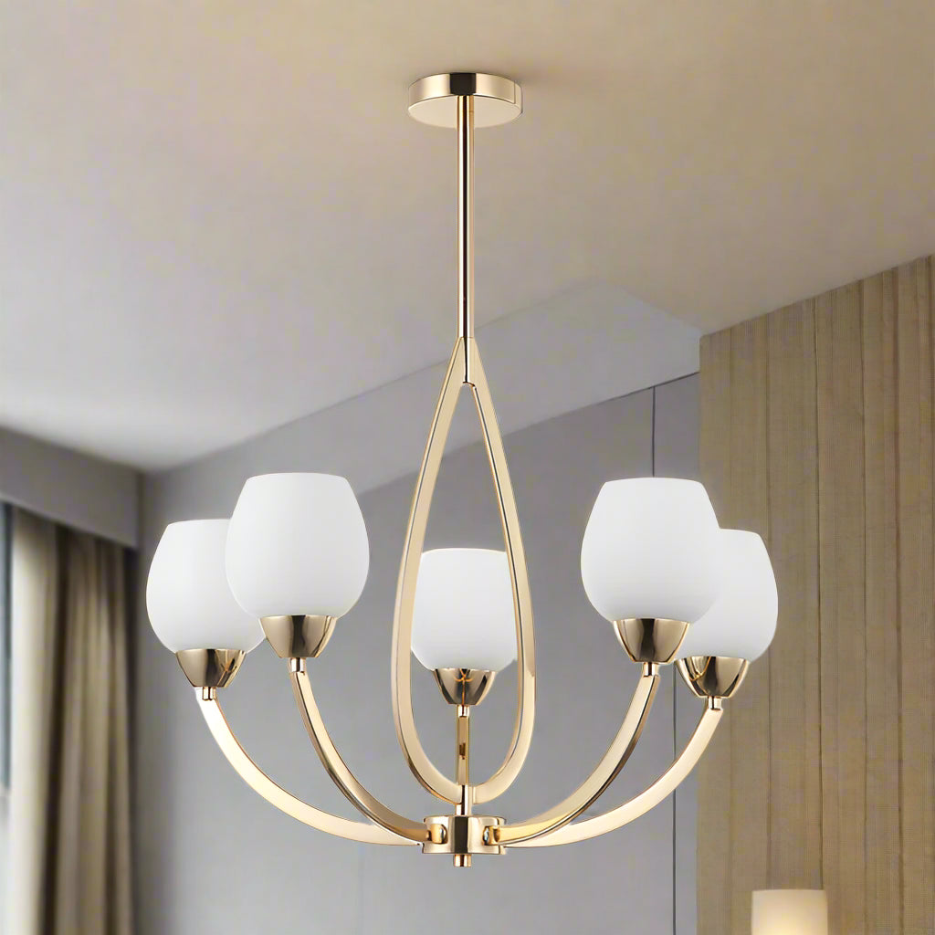 Gold chandelier with white glass shades on a white background