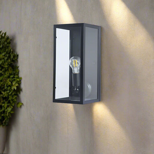 Black wall-mounted light fixture with a visible light bulb on a white background