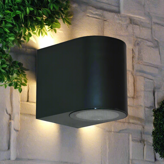 Black cylindrical wall light fixture on a white background