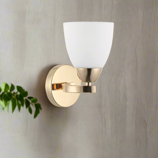 Wall sconce with gold finish and white shade on a white background